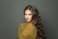 Good looking beautiful brunette woman with long shiny dark wavy hair against black studio wall background Royalty Free Stock Photo