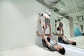 Good-looking couple loving sport doing yoga near wall together