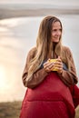 Good-looking female holding cup of tea in hands standing in contemplation of nature Royalty Free Stock Photo