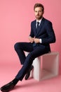 Businessman sitting and fixing his jacket`s button serious Royalty Free Stock Photo
