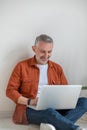 Good-looking gray-haired man working on laptop Royalty Free Stock Photo