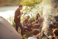 Good looking guy is singing songs to his friends at campsite