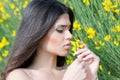 Good looking lady smelling yellow flower