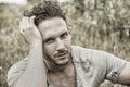 Good looking male model sitting on grass