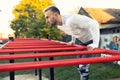 Good looking muscular young man working out on the horizontal ladder under the sky, outdoors workout Royalty Free Stock Photo