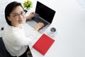 Good looking senior Asian businesswoman sitting at desk and working with notebook computer and cup of coffee Royalty Free Stock Photo