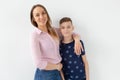 Good-looking single-parent mom and teen son on white background. Cohesion, friendship and family relations. Royalty Free Stock Photo