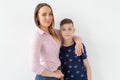 Good-looking single-parent mom and teen son on white background. Cohesion, friendship and family relations. Royalty Free Stock Photo