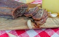 Good looking slices of smoked beef meat, garlic cloves, cheese and bread as a traditional and delicious meal on retro picnic style