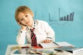 Good looking, smart casual dressed child, blond boy with tie, working on tablet, taking notes and talking on the phone, business Royalty Free Stock Photo