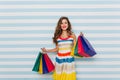 Good-looking stylish girl enjoying sales. Studio photo of wonderful long-haired woman in striped dress.. Royalty Free Stock Photo