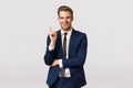 Good-looking, successful and rich young businessman, have creative idea, raising index finger in eureka gesture, smiling