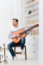 Good looking talented man holding the guitar