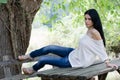 Good looking woman sitting on a wooden table