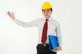 A good looking young architect in formal white shirt, wearing yellow helmet holding blue document folder, making welcoming or Royalty Free Stock Photo