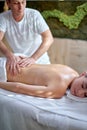 Good-looking young caucasian woman relaxing at spa center receiving back massage Royalty Free Stock Photo