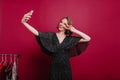 Good-looking young female model with tattoo taking picture of herself in dressing room. Indoor photo of laughing girl