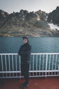 Good looking young man looking forward and smiling while standing on the deck of a ship in the Arctic. On Board Sarfaq Royalty Free Stock Photo