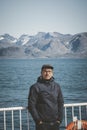 Good looking young man looking forward and smiling while standing on the deck of a ship in the Arctic. On Board Sarfaq Royalty Free Stock Photo