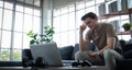 A good-looking young man sitting on a laptop or notebook with a worried, worried and bored expression on his face . A young man Royalty Free Stock Photo
