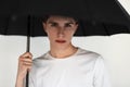 Good-looking young man in stylish casual t-shirt with fashion black umbrella isolated on white background in studio.  pretty Royalty Free Stock Photo