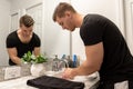 Good Looking Young Man Washing Hands and Face in Home Bathroom Mirror and Sink Getting Clean and Groomed During Morning Routine Royalty Free Stock Photo