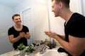 Good Looking Young Man Washing Hands and Face in Home Bathroom Mirror and Sink Getting Clean and Groomed During Morning Routine Royalty Free Stock Photo