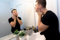 Good Looking Young Man Washing Hands and Face in Home Bathroom Mirror and Sink Getting Clean and Groomed During Morning Routine Royalty Free Stock Photo