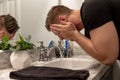 Good Looking Young Man Washing Hands and Face in Home Bathroom Mirror and Sink Getting Clean and Groomed During Morning Routine Royalty Free Stock Photo