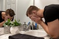 Good Looking Young Man Washing Hands and Face in Home Bathroom Mirror and Sink Getting Clean and Groomed During Morning Routine Royalty Free Stock Photo