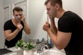 Good Looking Young Man Washing Hands and Face in Home Bathroom Mirror and Sink Getting Clean and Groomed During Morning Routine Royalty Free Stock Photo