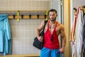 Good-looking young muscular man in gym dressing room