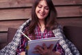 Good-looking young woman smiling while making notes in a jotter