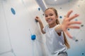 Girl climbing wall and reaching out to camera Royalty Free Stock Photo