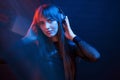 Good mood for all. Studio shot in dark studio with neon light. Portrait of young girl Royalty Free Stock Photo