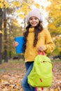 Good mood at any weather. child carry books for study. girl in earphones with school bag. kid listen music in autumn