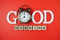 Good Morning alphabet letters with alarm clock on red background