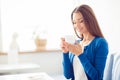 Good morning! Close up portrait of charming dreamy brunette young girl drinking coffee. She is sleepy and relaxed, in casual blue Royalty Free Stock Photo