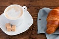 Good morning with coffee. A cup of hot aromatic coffee, espresso or cappuccino with a French croissant on a wooden table. Coffee Royalty Free Stock Photo