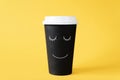 Good morning with coffee. Disposable cup of coffee with painted smiling face. Cheerful morning Royalty Free Stock Photo