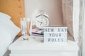 Good morning concept. Inspiration Motivational Life Quotes New day your rules message on lightened box with alarm clock, notebooks