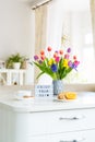 Good morning concept. Romantic breakfast - fresh flowers, cup of hot drink, cookies, orange, lightbox with message Enjoy your day