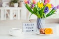 Good morning concept. Romantic breakfast - fresh spring flowers, cup of hot coffee drink, cookies, orange, lightbox with message