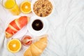 Good morning. Continental breakfast on white bed sheets.