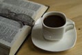 A Cup of coffee on a warm background. The open Bible. Glasses. Royalty Free Stock Photo