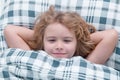 Good morning. Cute awaking child in bed, bedtime, childhood and growth kids concept, close-up indoor portrait.