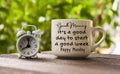 Good Morning, it is a a good day to start a good week text on coffee cup with alarm clock pointing at 8am. Morning