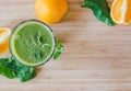 Good morning: Fresh green smoothie and fruits on wooden background, healthy breakfast. Text space
