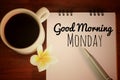 Good morning Monday. Happy Monday concept. With a cup of morning coffee, text message on notebook, pen and a flower. Royalty Free Stock Photo