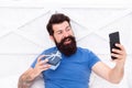 Good morning. Special gift. Bearded man using mobile technology in bed. Handsome guy taking selfie with gift box. Happy Royalty Free Stock Photo